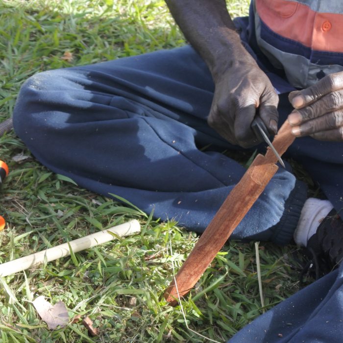 Unrecognizable Indigenous Australians aboriginal craftman making a  a wooden Australian Aboriginal spear.Many aboriginal weapons are for hunting as well as warfare.